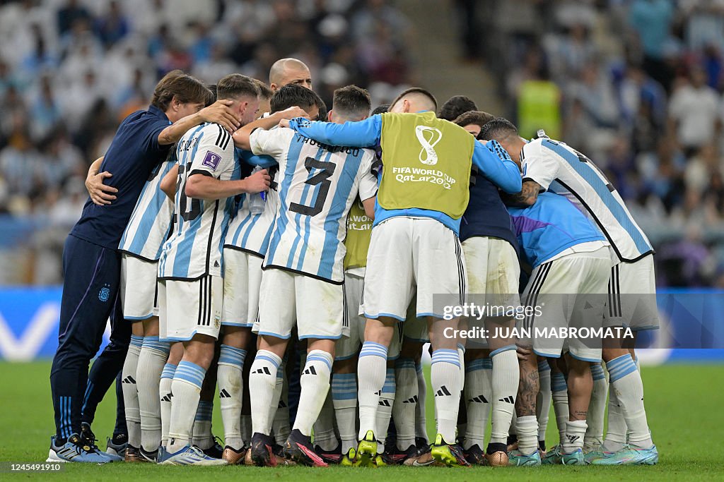 Argentina players in a team huddle before a difficult World Cup match under stadium lights