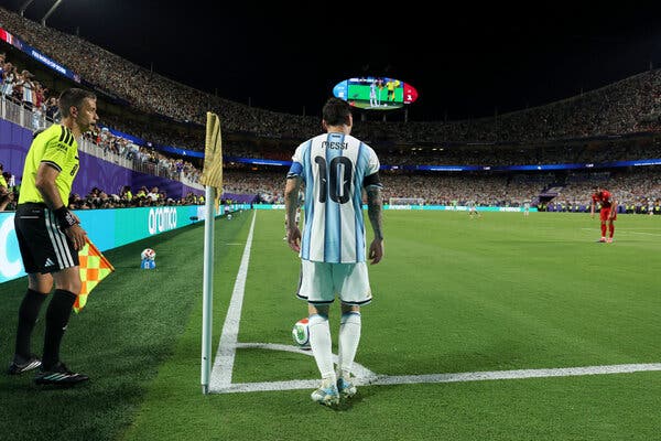 Lionel Messi in Argentina colors facing England players beneath bright World Cup stadium lights