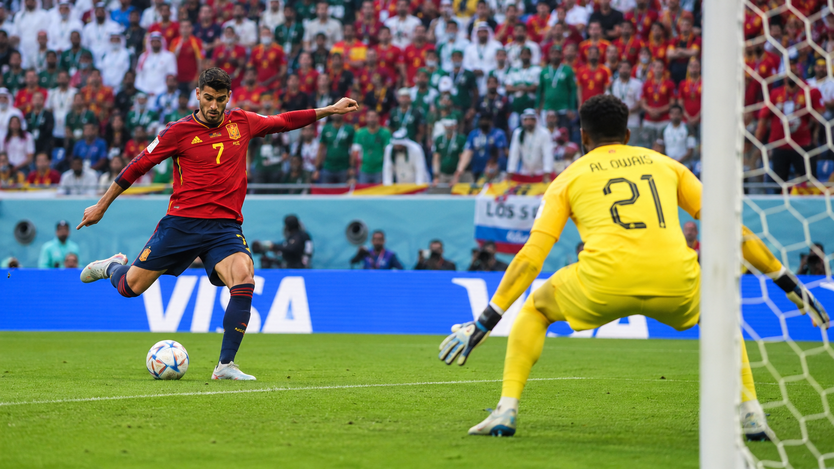 Spanish forward taking a shot while Saudi goalkeeper prepares to dive in a bright World Cup stadium